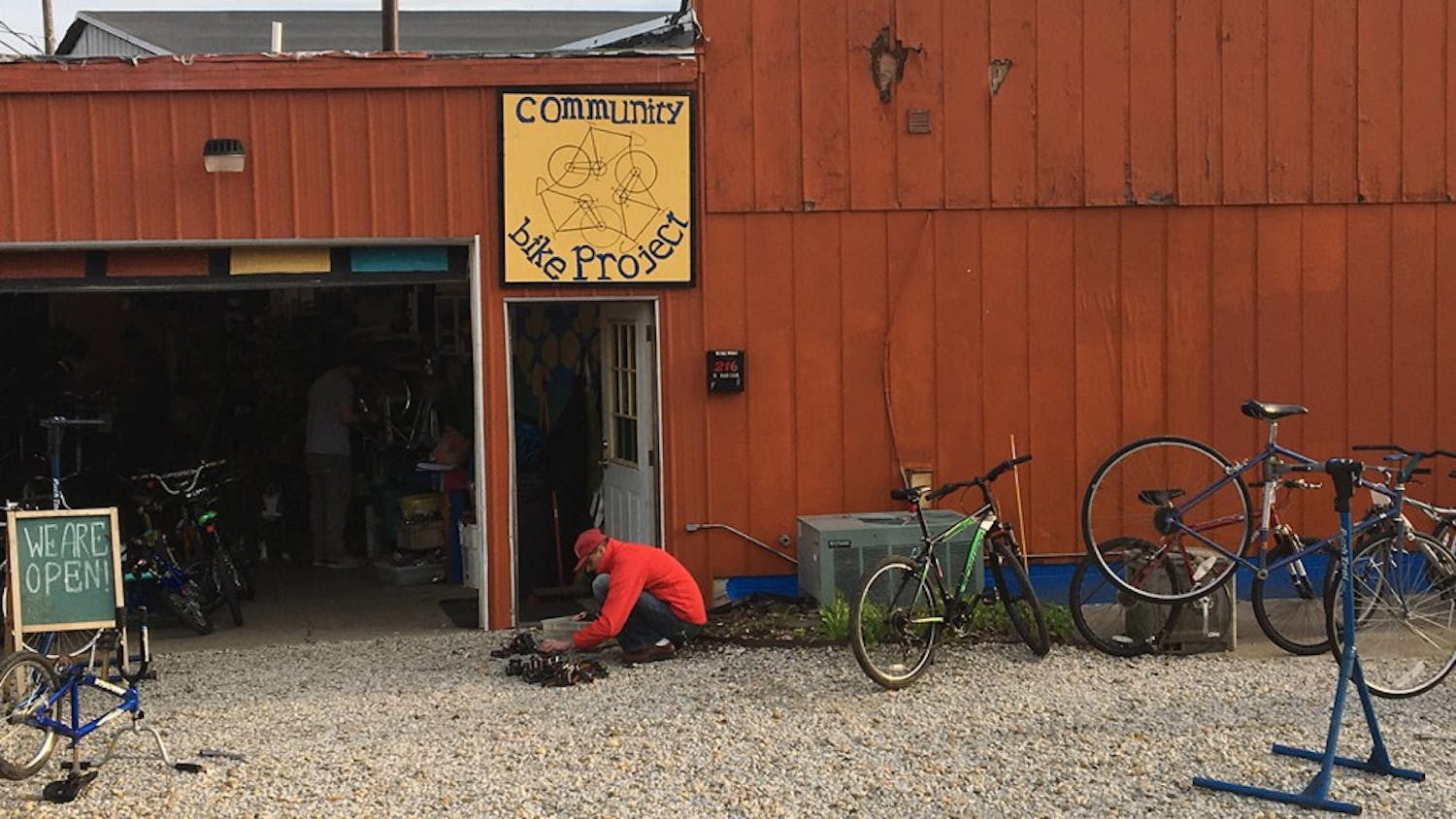A Bloomington Community Bike Project patron looks through a drawer of bike parts, searching for a new pedal. The shop offers free tools and parts for people to repair bikes.