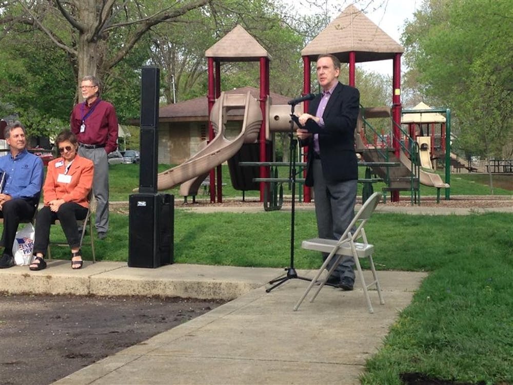 Bloomington Mayor Mark Kruzan presents at the unveiling of a new interpretive sign Monday evening at Building and Trades Park. 