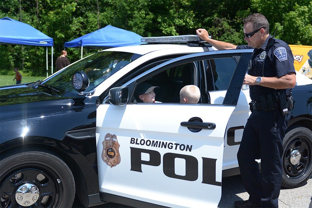 Trae Luck, officer at Bloomington Police Department, talks to Oliver and Isaiah Gough while they experience the front seat of a police car during the "Touch a Truck" event held Wednesday afternoon. Luck has been there since 10 in the morning. He said some parents told him their kids couldn’t wait to see a police car. “It’s fun to watch them get excited,” Luck said. 