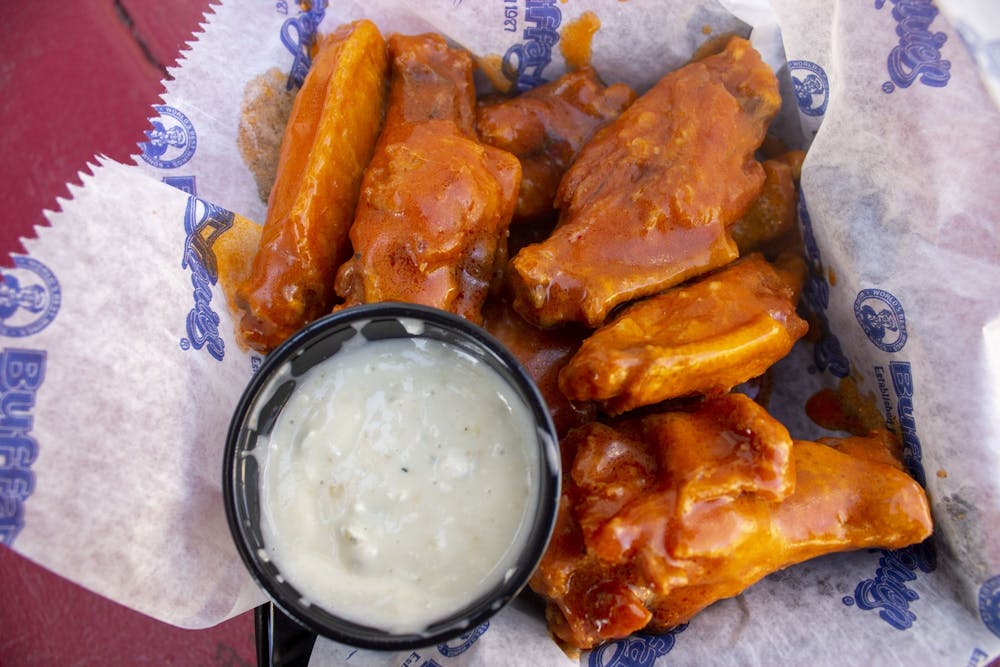 <p>Wings from BuffaLouie’s sit on a table. </p>