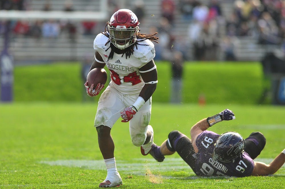 Junior running back Devine Redding breaks past a Northwestern defender on Saturday at Ryan Field in Evanston, Ill. Indiana lost, 24-14.