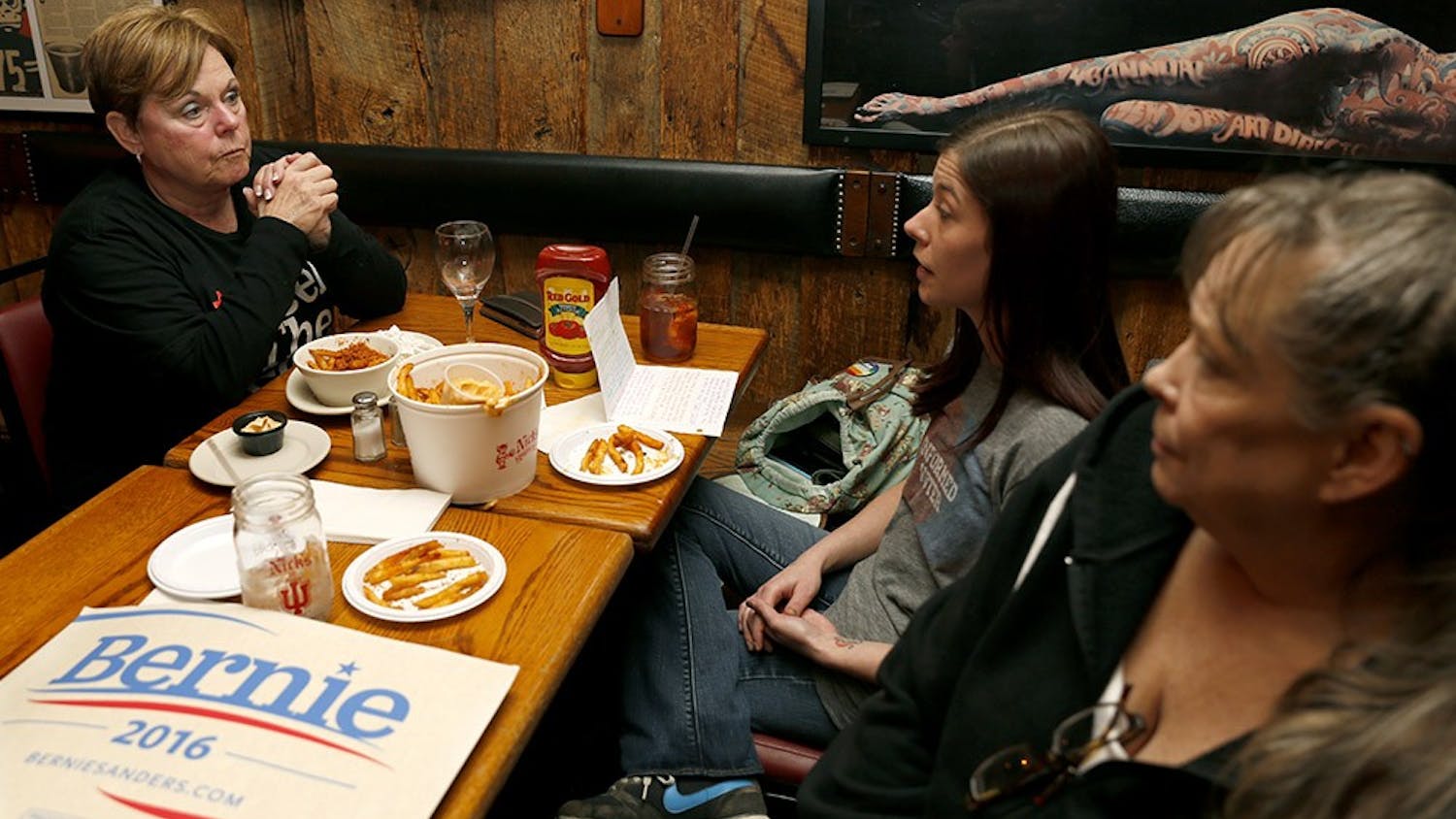 Ruth Simcox, left, Jessica Martlage, and Shellie Martlage talk before the CNN Democratic debate begins Wednesday at the Nick's English Hut. Bloomington Bernie Supporters opened a group meeting to watch the debate and support Bernie Sanders.