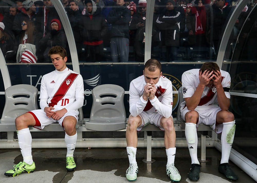 From left, freshman midfielder Justin Rennicks, junior defender Andrew Gutman and junior midfielder Jack Griffith sit on the bench while the NCAA Championship trophy is presented to Stanford after IU lost 1-0 to Stanford in overtime on Dec.10 in Chester, Pennsylvania. Stanford scored a goal in the 103rd minute of the game.