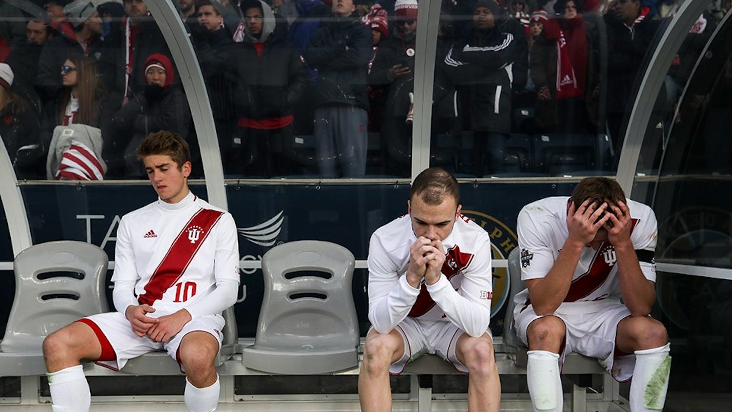 From left, freshman midfielder Justin Rennicks, junior defender Andrew Gutman and junior midfielder Jack Griffith sit on the bench while the NCAA Championship trophy is presented to Stanford after IU lost 1-0 to Stanford in overtime on Dec.10 in Chester, Pennsylvania. Stanford scored a goal in the 103rd minute of the game.