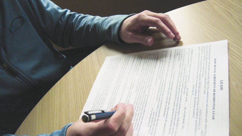 A student signs a lease. Many students sublease their homes during the academic year to study abroad or graduate early.