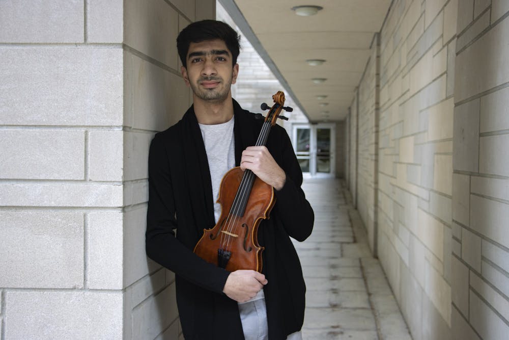 <p>Mehran Fanoos poses for a picture with his violin on March 8, 2022, outside of the Simon Music Library and Recital Center. Fanoos fled Afghanistan for India in ninth grade and is currently in his first semester at IU.</p>