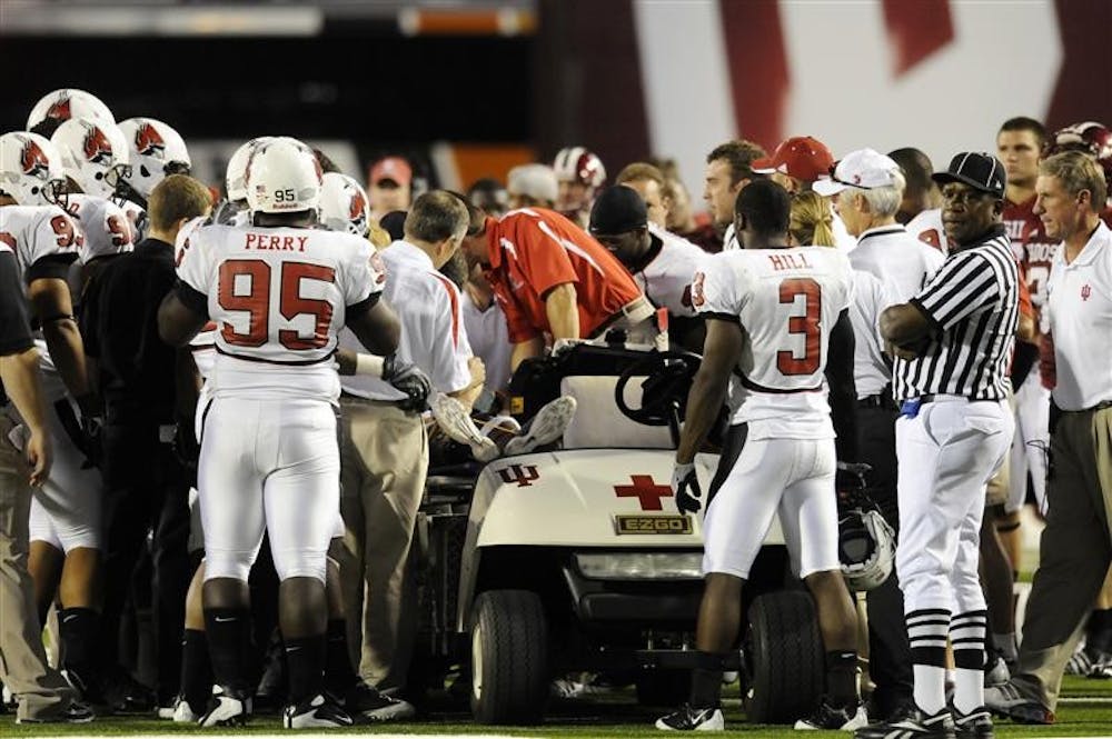 Ball State players watch as paramedics attend to teammate Dante Love after he was hit hard by a IU player in the second quarter on Saturday night at Memorial Stadium. Love lay motionless on the field for about 15 minutes as the medical staff attended to him.