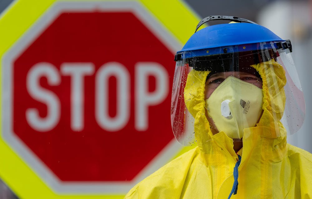<p>A firefighter in protective clothing stands in front of a stop sign March 11 during a check of travelers at a petrol station on the D8 Dresden-Prague motorway. To prevent the coronavirus from spreading, the Czech Republic has started random checks of travelers at the borders to Germany and Austria. </p>