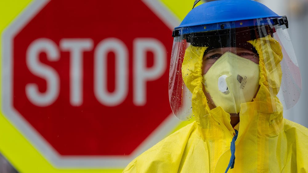 A firefighter in protective clothing stands in front of a stop sign March 11 during a check of travelers at a petrol station on the D8 Dresden-Prague motorway. To prevent the coronavirus from spreading, the Czech Republic has started random checks of travelers at the borders to Germany and Austria. 