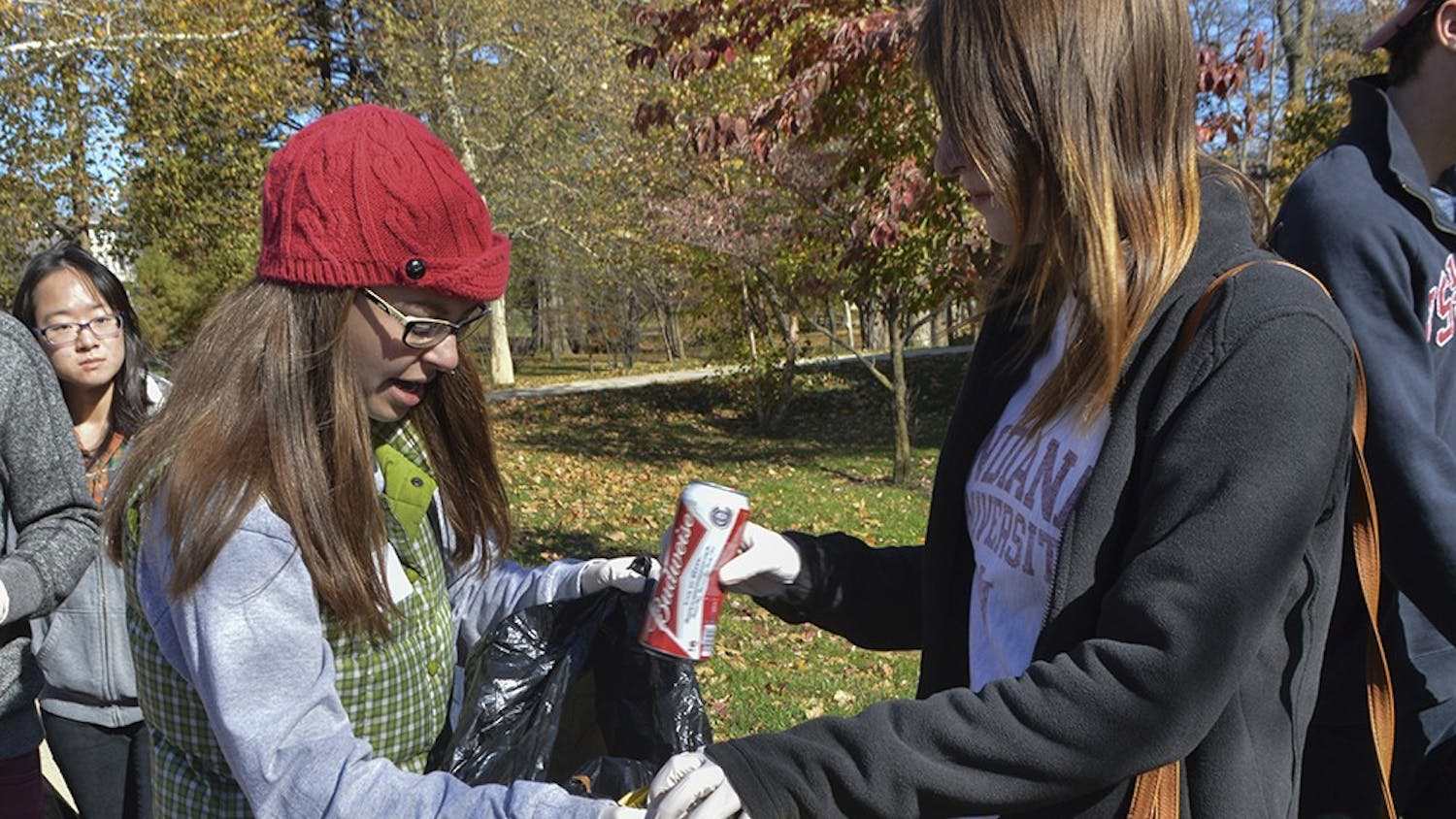 Junior Shelby Fletcher holds the trash bag for Sophomore Lauren Daas as they clean up Sunday near Franklin Hall as part of the Civic Leadership Development Campus Cleanup.