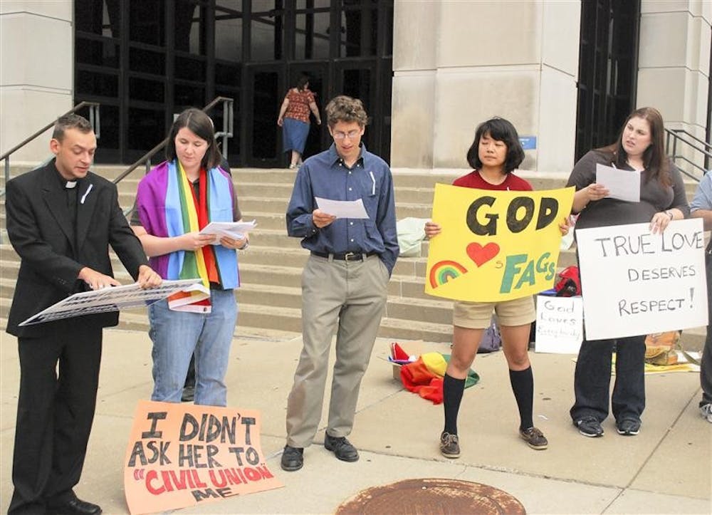 Members of the Bloomington Gay Recruiters group conduct a marriage equality sit-in on Thursday morning outside the Monroe County Justice Building. Along with signs, the group also chanted “1,138 federal rights denied. I am a gay American and I am a second-class citizen.”