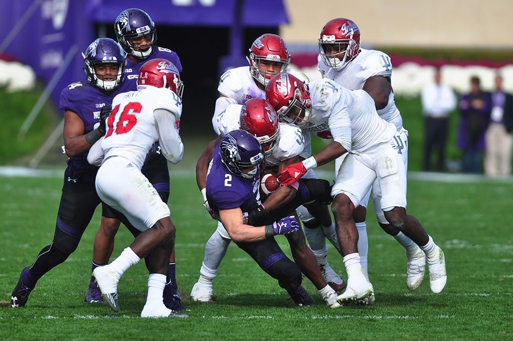 Indiana defenders bring down Northwestern's Flynn Nagel on Saturday at Ryan Field in Evanston, Ill. IU lost 24-14.
