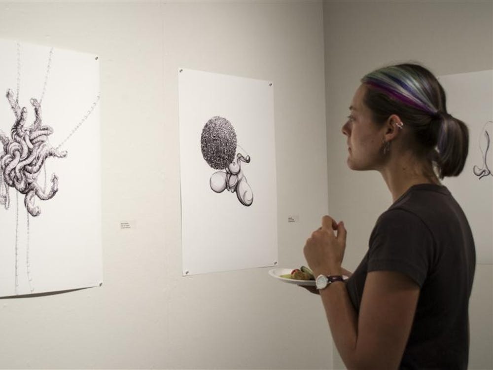 Bloomington resident Falyn Owens examines drawings by Dutch artist Miek van Dongan on Friday in the Grunwald Gallery of Art. The images are part of the exhibit "Media Life," which includes projected digital artwork.