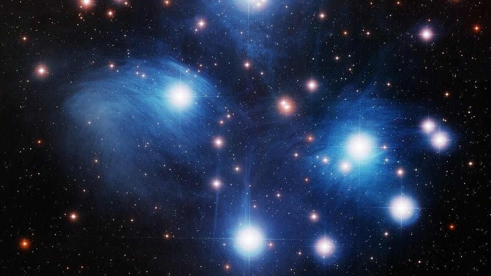 A wide-field view is shown of the Pleiades Star Cluster. Attribution to: NOIRLab/NSF/AURA/T.A. Rector (University of Alaska Anchorage), Richard Cool (University of Arizona) and WIYN. 
