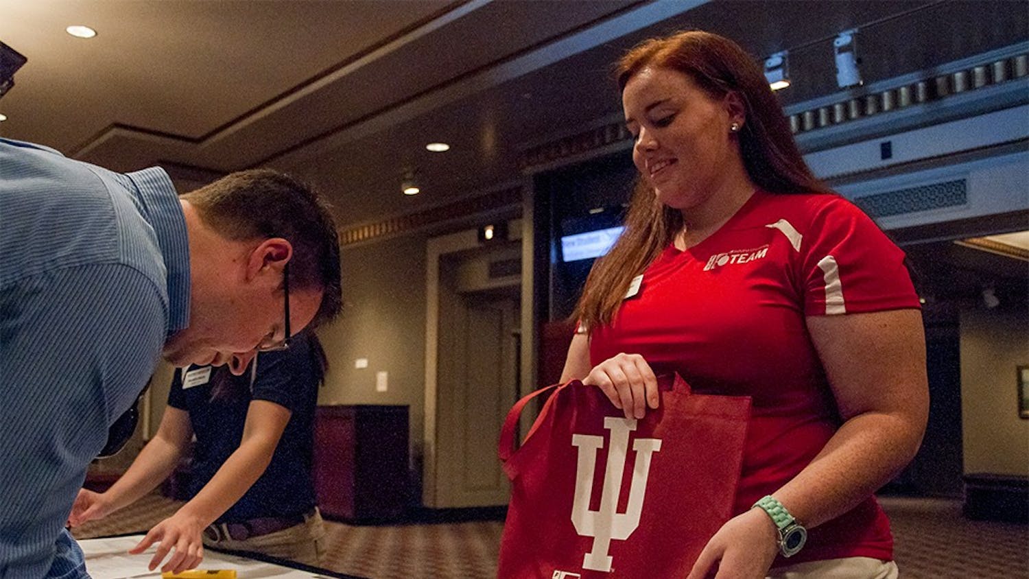 Jordan Spoor, a senior student who studies Elementary Education, helps a student parent to sign in on Monday afternoon at the Indiana University Auditorium. She was one of the program leaders on new student orientation team.