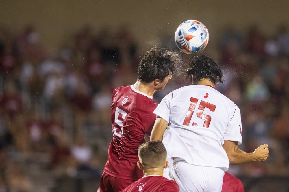 <p>Then-junior defender Daniel Munie challenges the opposing defender in the air on Sept. 17, 2021, at Bill Armstrong Stadium. Indiana won Tuesday&#x27;s match 1-0 against St. John&#x27;s University.</p>