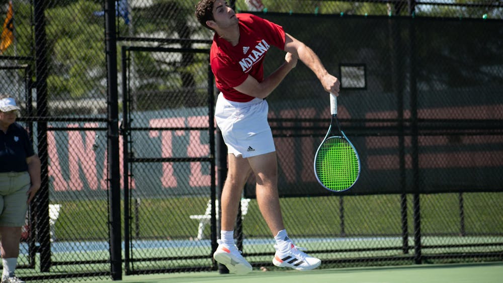 Freshman Sam Landau comes down from a serve April 15, 2023, at the IU Tennis Center. Indiana men&#x27;s tennis fell to Michigan and Michigan State over the weekend.