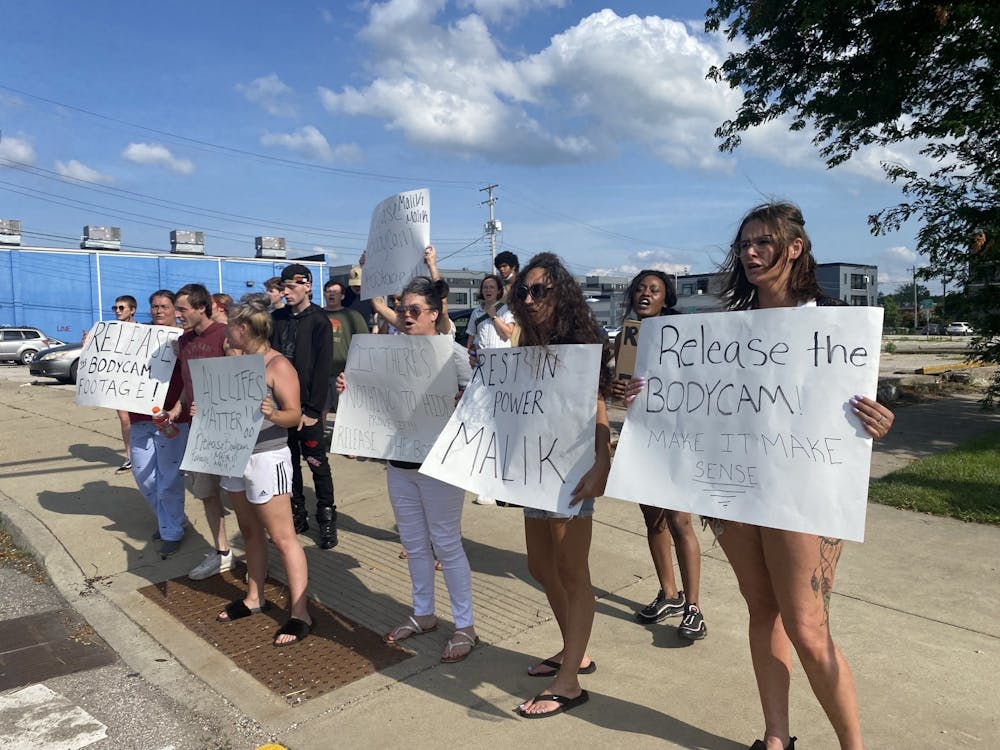 Protesters stand at a vigil for Malik Ali Malik on Saturday in Bloomington. Malik died April 17th after a police chase with Monroe County Sheriff's Office deputies. 