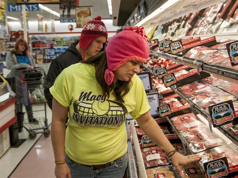 Cassie Winders shops at Kroger with her two oldest children, Patrick and Alivia, for forgotten ingredients for Monday night dinner soon after receiving her food stamps. Cassie says she often looks at the meat that is discounted as it hits its expiration date.