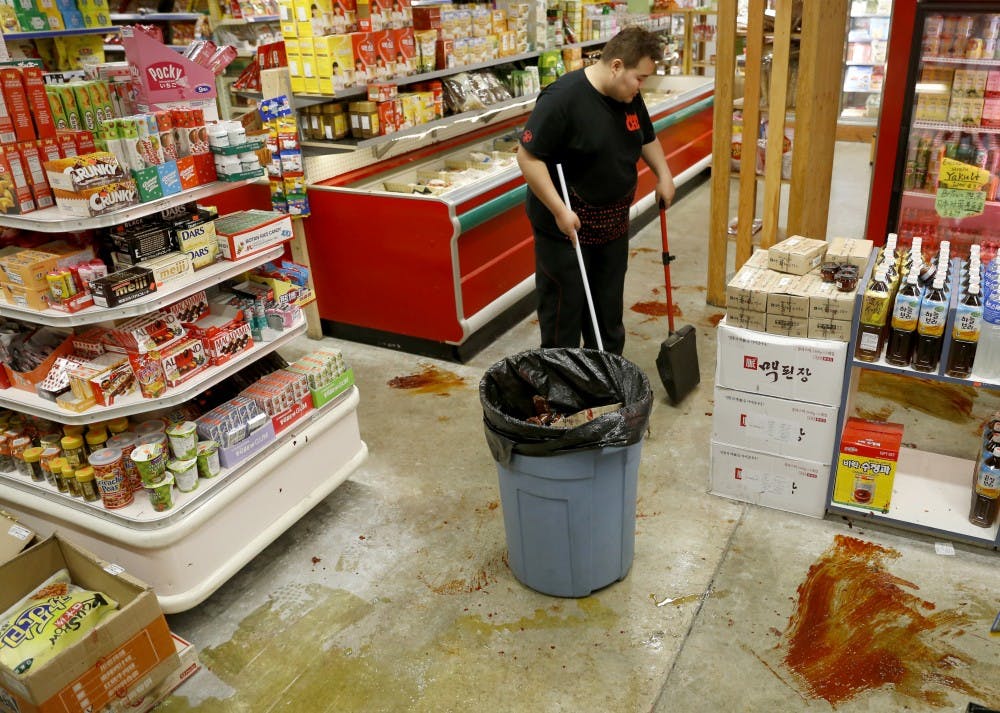 Felix Guan cleans the mess Sunday at B-Town International Market. 