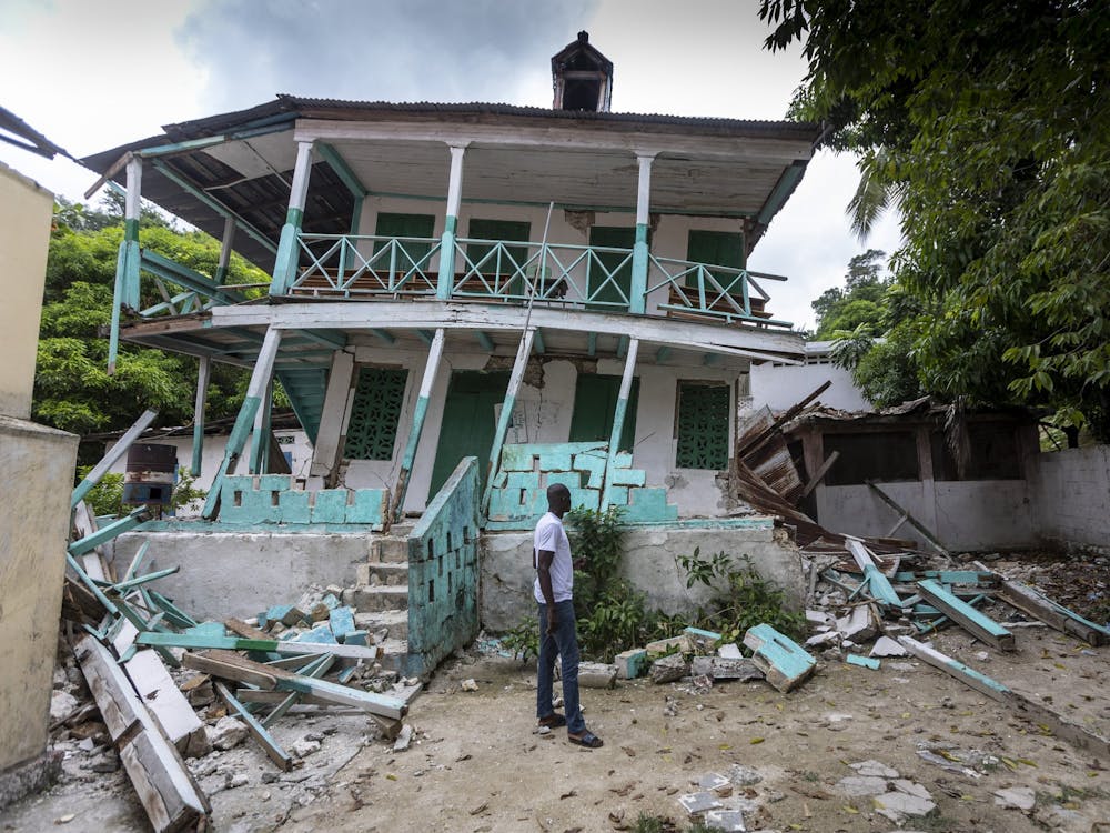 A man stands in front of a damaged school in Corail, Haiti, on Aug. 19, 2021. Many structures in this small fishing village were damaged or destroyed by the earthquake. 