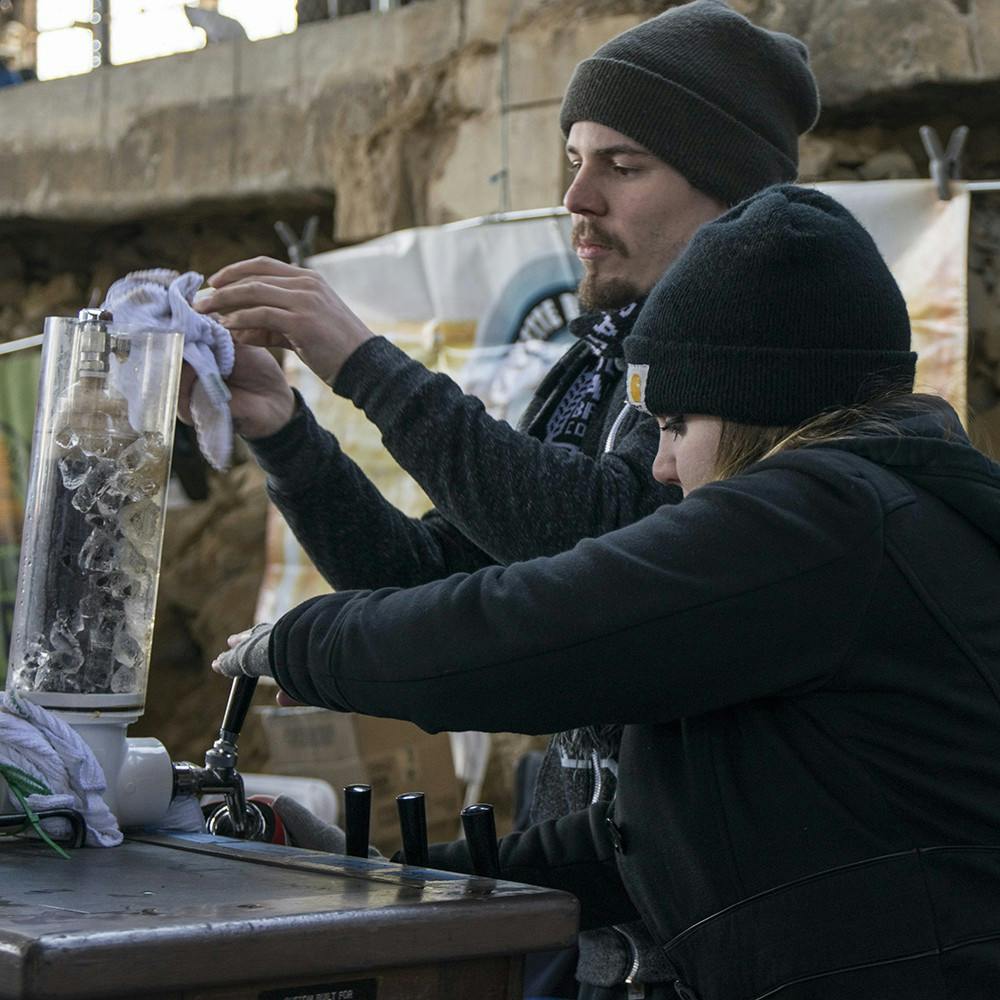 Stacy Spellman, left, and Patrick Schwomeyer hand out beer during the sixth annual Bloomington Craft Beer Festival at Woolery Mill on Saturday afternoon. People can taste hundreds of local and regional draft beers during the festival that is organized by Brewers of Indiana Guild, a non-profit trade association that provides services for Indiana’s craft breweries.
