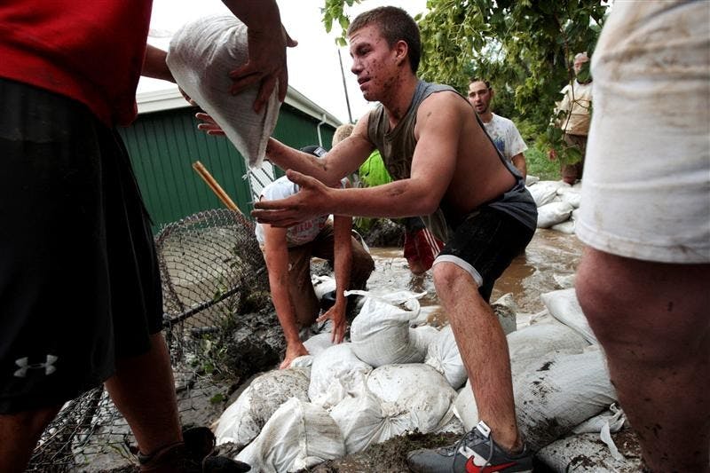 Colin Hammermeister, a Munster, Ind. high school football player, helps patch up areas along the Little Calumet on Sunday after the Little Calumet river spilled its banks flooding Munster and Hammond, Ind.