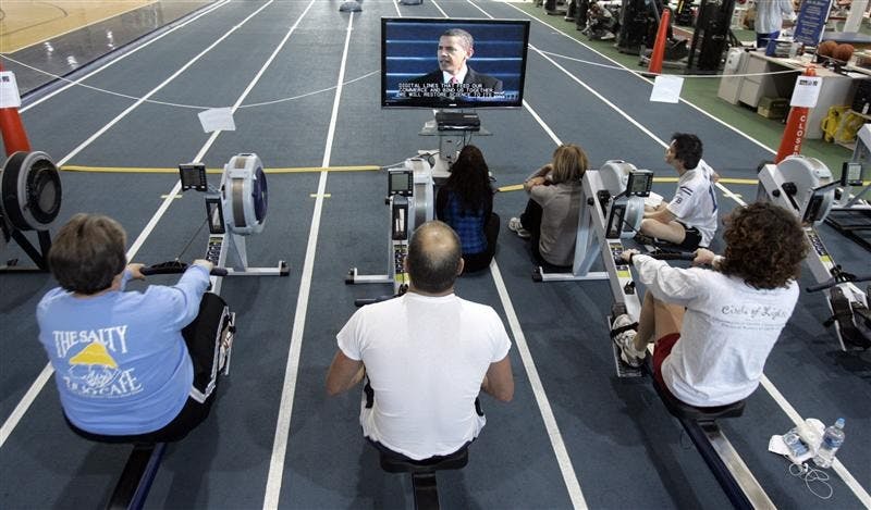 Members of the National Institute for Fitness and Sport watch as President Barack Obama is sworn into office as they continue to work out on the gym's rowing machines Tuesday in Indianapolis.
