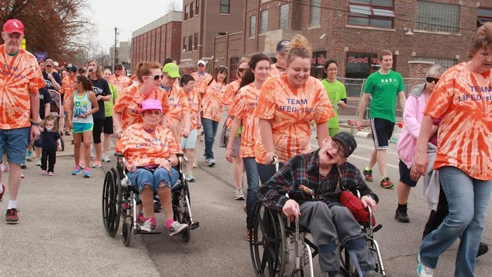 Shanna Schmutte pushes John Langey down South Washington Street April 13, 2014, at the 12th Annual Homeward Bound 5K Walk. IU-Bloomington and the City of Bloomington will host events and programs this month in recognition of Disability Awareness Month.  