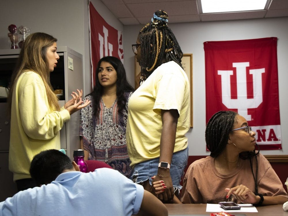 Two IU Student Government members hold hands as they gather following an executive branch meeting. IU Student Government has begun the electoral progress for next year&#x27;s representatives. 