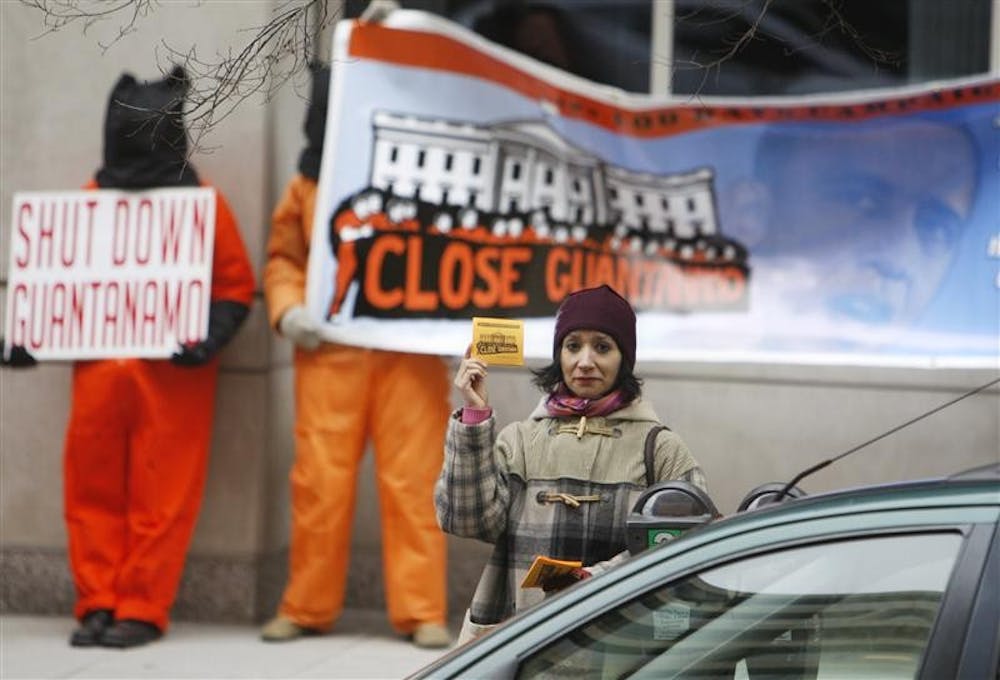 Protesters, some dressed as prisoners, demand the closure of Guantanamo Bay prison as they stand across from the transition offices of President-elect Barack Obama Tuesday in Washington.