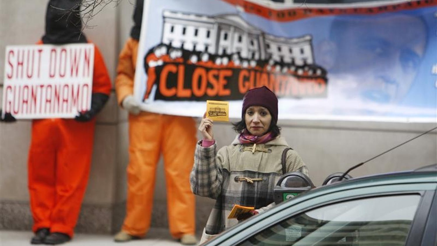 Protesters, some dressed as prisoners, demand the closure of Guantanamo Bay prison as they stand across from the transition offices of President-elect Barack Obama Tuesday in Washington.