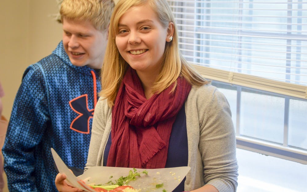 Freshmen Emily Vetne and Mitchell Spangler enjoy Middle Eastern food like tabbouleh and manakish during the Cooking Demonstration Friday evening at the Asian Culture Center. The event was hosted by Professor Iman Alramadan and she invited her Elementary Arabic class to enjoy some of her international cuisine.