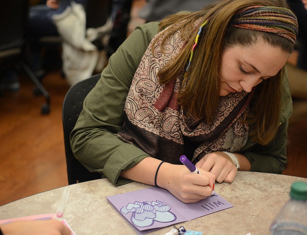 Madison Wise, junior student of IU, makes valentine cards during the event held by the college internship program and Autism Mentoring Program (AMP). Ali Matisko, student intern at AMP, said this event intent to spread awareness of autism and students with special needs.