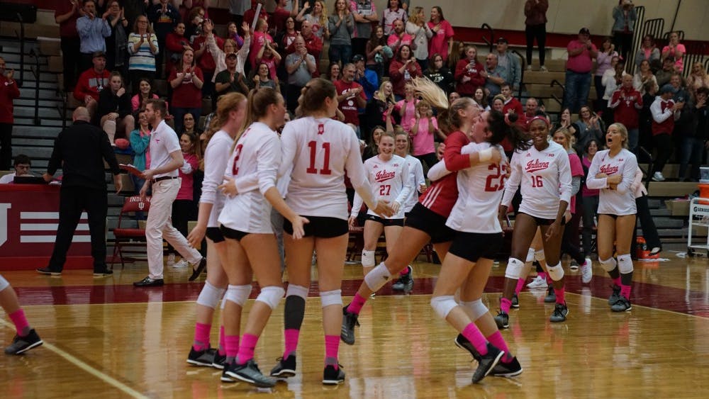 Kamryn Malloy lifts Bayli Lebo up in the air in joy as the rest of the team rushes to celebrate its victory against Ohio State on Oct. 19 in University Gym. IU swept Ohio State, 3-0.