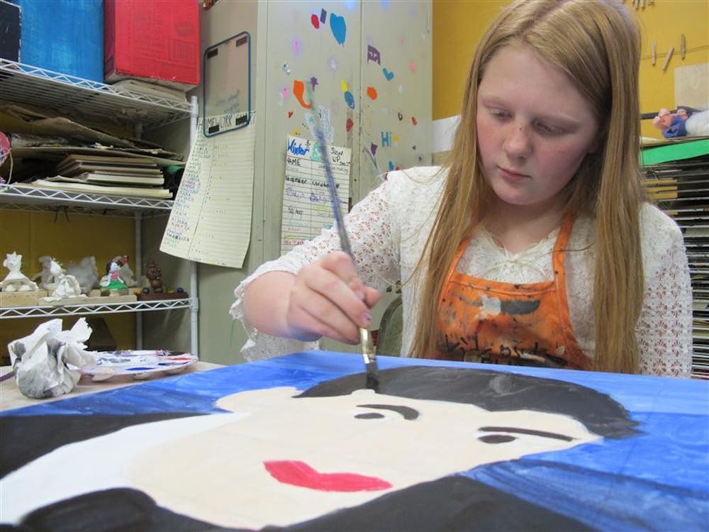  A child creates a painting of Hoagy Carmichael on Wednesday to raise funds for the local organization at the Bloomington Boys and Girls Club.