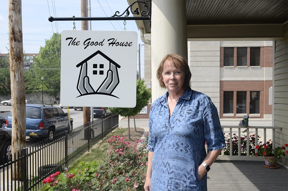 Becky Armbruster, founder and runner of The Good House, stands at the front porch of the building on Saturday. The Good House provides short term housing for patients that come from outside of town to treatment at IU Cancer Center. Armbruster estabished The Good House with family, friends, and nurses from the hospital's help in 2012 after her husband passed away to help people who are facing cancer treatments.