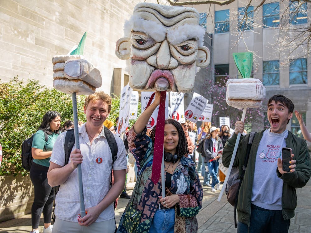 Undergraduates John Hogan, Bella Brown and River Epperson show off a homemade caricature of the IU provost on April 14, 2022, at Ballentine Hall. Many undergraduate students were encouraged to support the graduate students&#x27; strike. 
