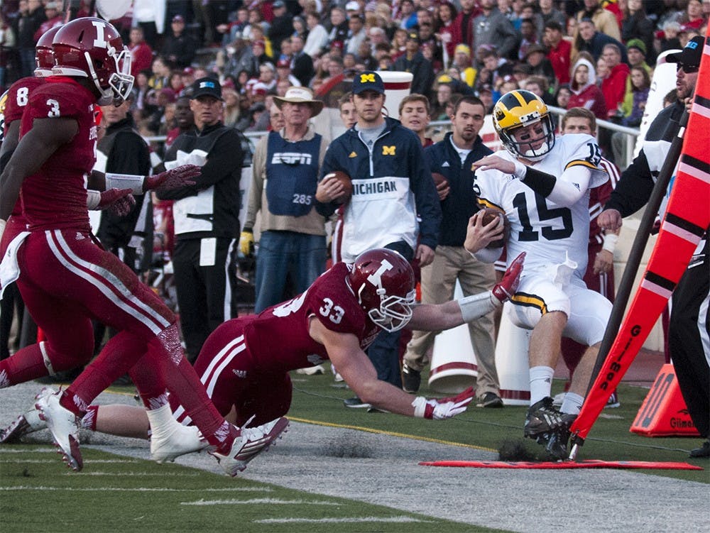 Red-shirt senior linebacker Zack Shaw (33) knocks Michigan quarterback Jake Rudock out of bounds on Saturday at Memorial Stadium. Shaw received a penalty for a late hit on the play.