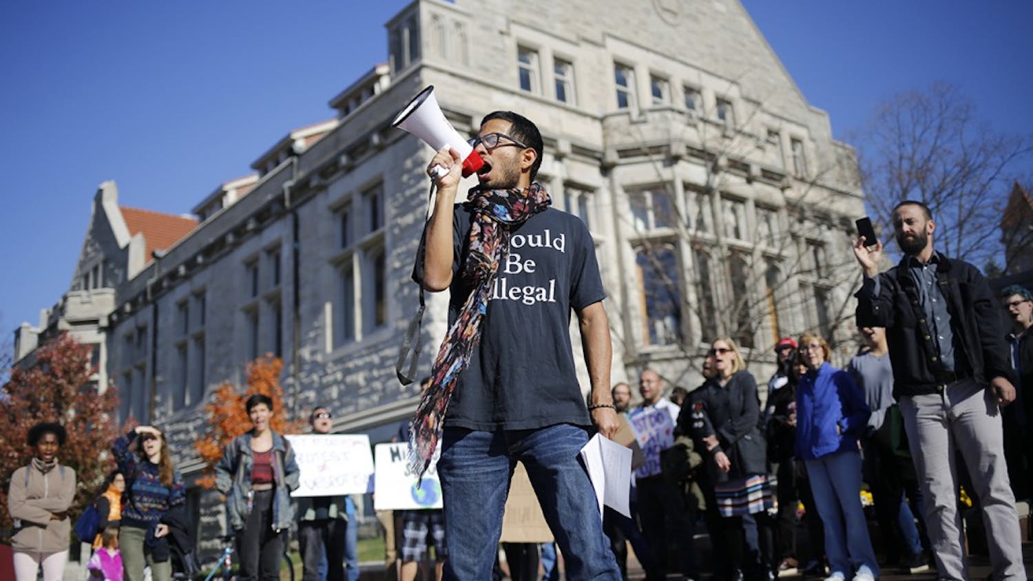 Willy Palomo yells into a megaphone while leading a group of students in a chant during a rally for a Sanctuary Campus Wednesday at Sample Gates. Palomo is with the UndocuHoosier Alliance and was rallying to bring awareness to isues facing undocumented students on IU's campus. "Hoosier Promise," he yelled. "Is a lie," the crowd followed up. "Only true," he yelled out again. "If you're white," the crowd finished.