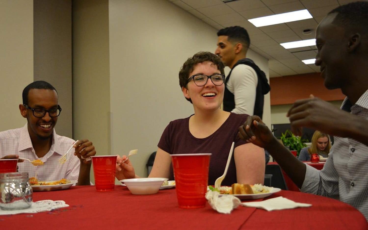 Junior Mohamed Abdirisak,&nbsp;freshman Becca Karstensen and senior Mohamed Mohamed laugh during a&nbsp;conversation at the "Taste of Islam" banquet. Students were invited to come learn about the culture of food in Muslim-majority countries at the Islam Awareness week event.