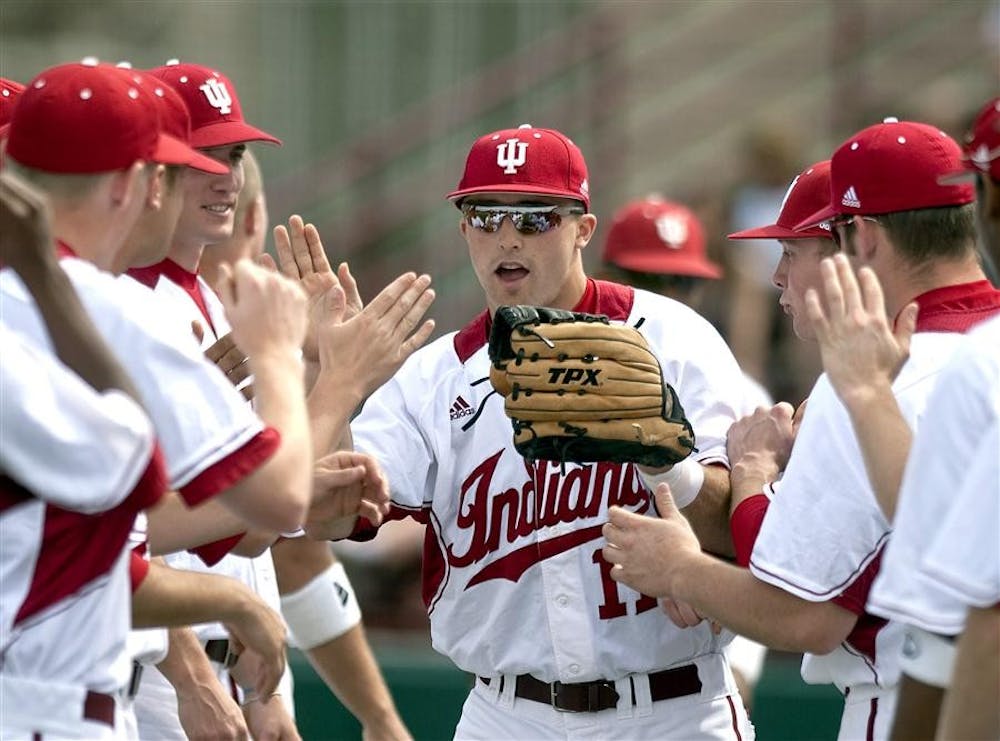 Senior Michael Earley high-fives teammates as he takes the field before IU's 16-10 loss to Michigan Sunday, April 4 at Sembower Field.