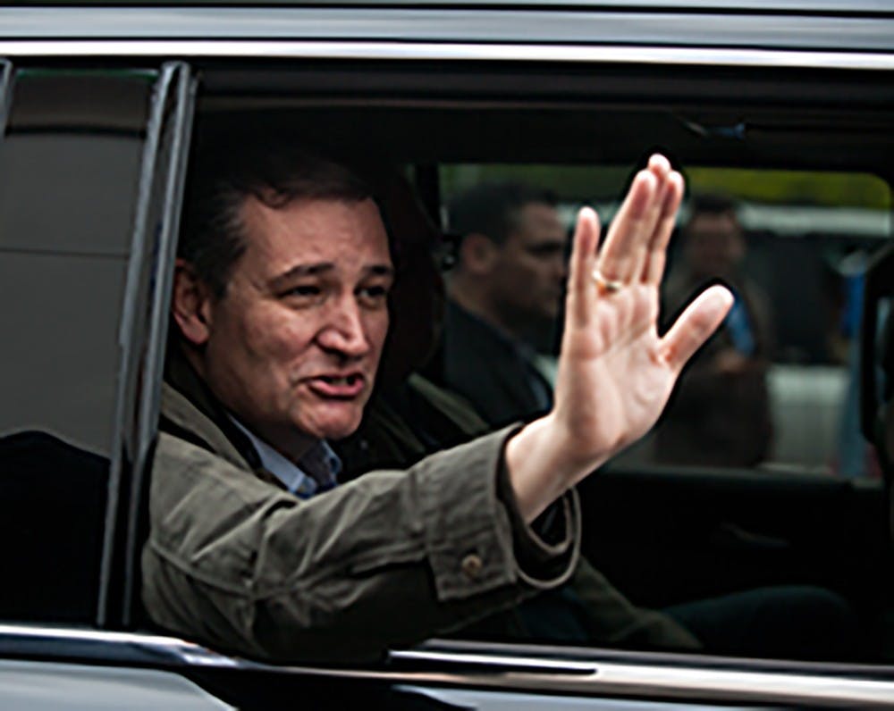 Sen. Ted Cruz waves goodbye to supporters from his motorcade after meeting Bloomington residents at Wagon Wheel Market & Deli on Monday.