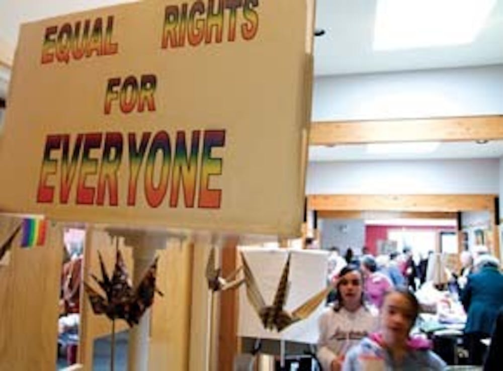 Two girls shuffle past a sign that reads "Equal rights for everyone" before Sunday service at the Unitarian Universalist Church.  According to sophomore Drake Holston, "Unitarianism really encourages a plethora of beliefs among its members."