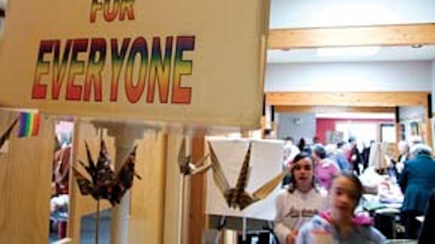 Two girls shuffle past a sign that reads "Equal rights for everyone" before Sunday service at the Unitarian Universalist Church.  According to sophomore Drake Holston, "Unitarianism really encourages a plethora of beliefs among its members."