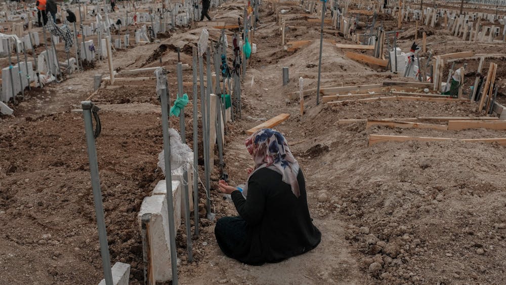 A woman mourns in front of a gravestone in the cemetery of Adiyaman, in Turkey, on Feb. 19, 2023. A 7.8 magnitude earthquake struck parts of Turkey and Syria on Feb. 6, 2023, followed by another 7.5 magnitude tremor just after midday.