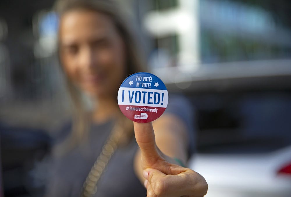 Sucel Peleg poses with her vote sticker after casting her ballot during early voting for the general election in Miami, Florida.