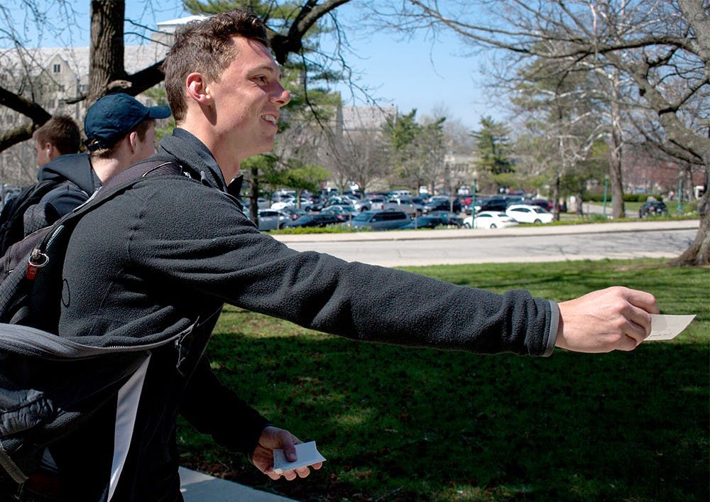 Senior Mac Conrad hands out positive post-it-notes during "Culture of Care's first Positive Post-It" event for the first time on the campus Monday. 