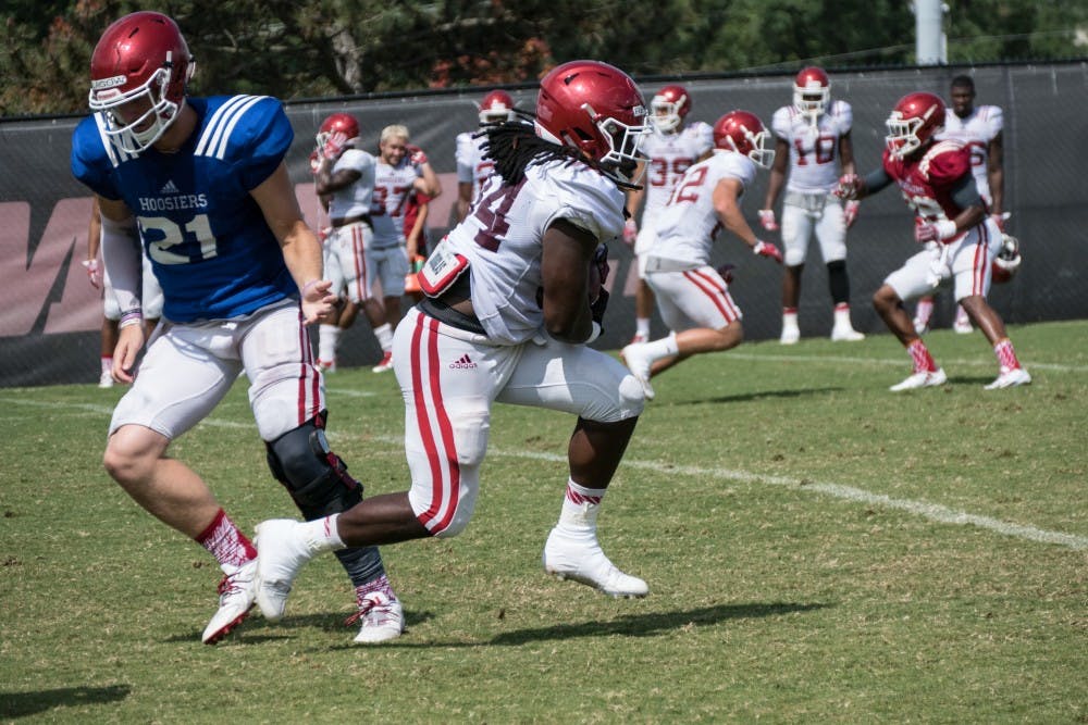 Junior running back Devine Redding receives a handoff from junior quarterback Richard Lagow during an IU fall camp practice.