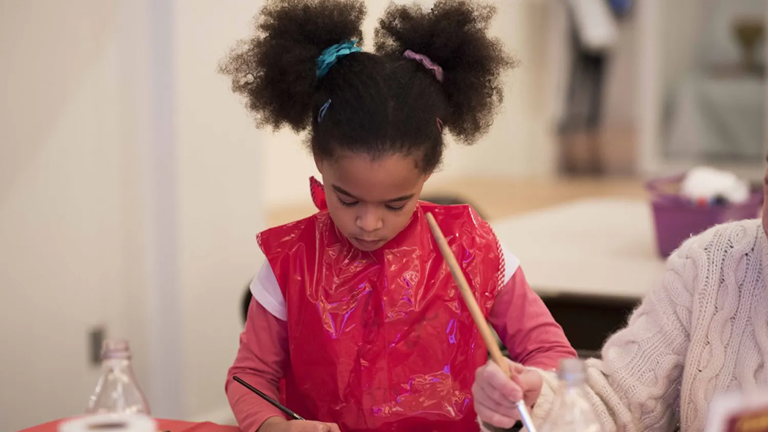 Evelyn Butler and her mother Emily Butler paint cherry blossoms in spirit of Chinese New Year. The art event took place at the Mathers Museum of World Cultures Sunday afternoon.